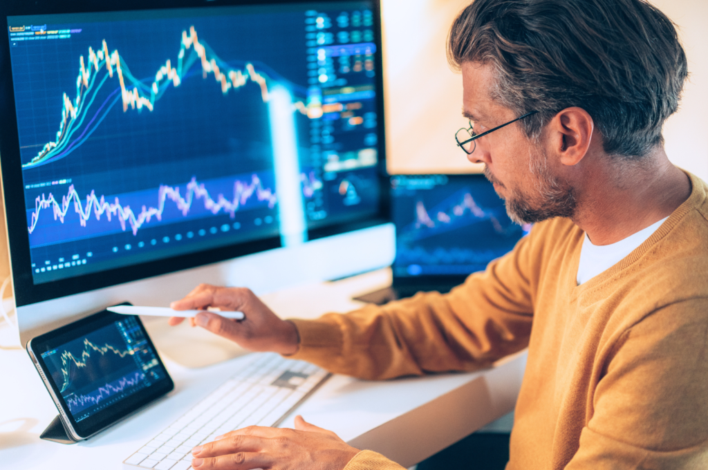a man in a yellow sweater is watching and calculating his cryptocurrency trading status 